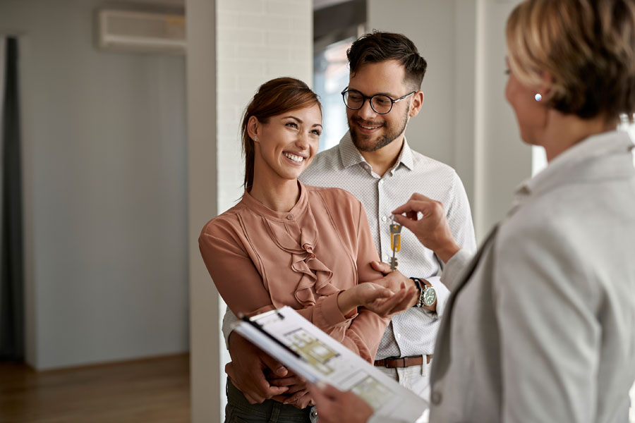 Couple receiving a key from a realtor